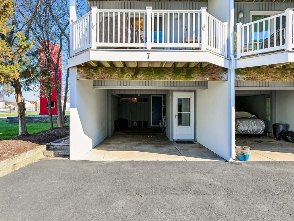 A two-story building with a balcony, a door, and a small outdoor area.