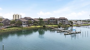A waterfront hotel with multiple-story buildings, a dock, and a marina. - Needle Rush Point E13 (Pensacola)