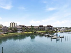 A waterfront hotel with multiple-story buildings, a dock, and a marina. - Needle Rush Point E13 (Pensacola)