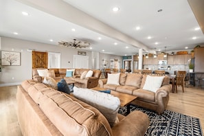 A spacious living area with leather sofas, a dining table, and a kitchen in the background. - 3br lodge TRL Near SDC Game Room Hot tub (Branson)