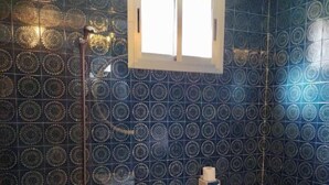A bathroom with a bathtub, toilet, and a window. - Hostal Pirineos Meliz (Bielsa)
