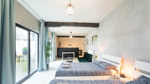A modern bedroom with two beds, a desk, and a fireplace. - Antwerp Central 1br/7p Apartment (Antwerp)
