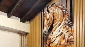 Una sala moderna con un sofá, una mesa de centro, un panel decorativo y una silla.