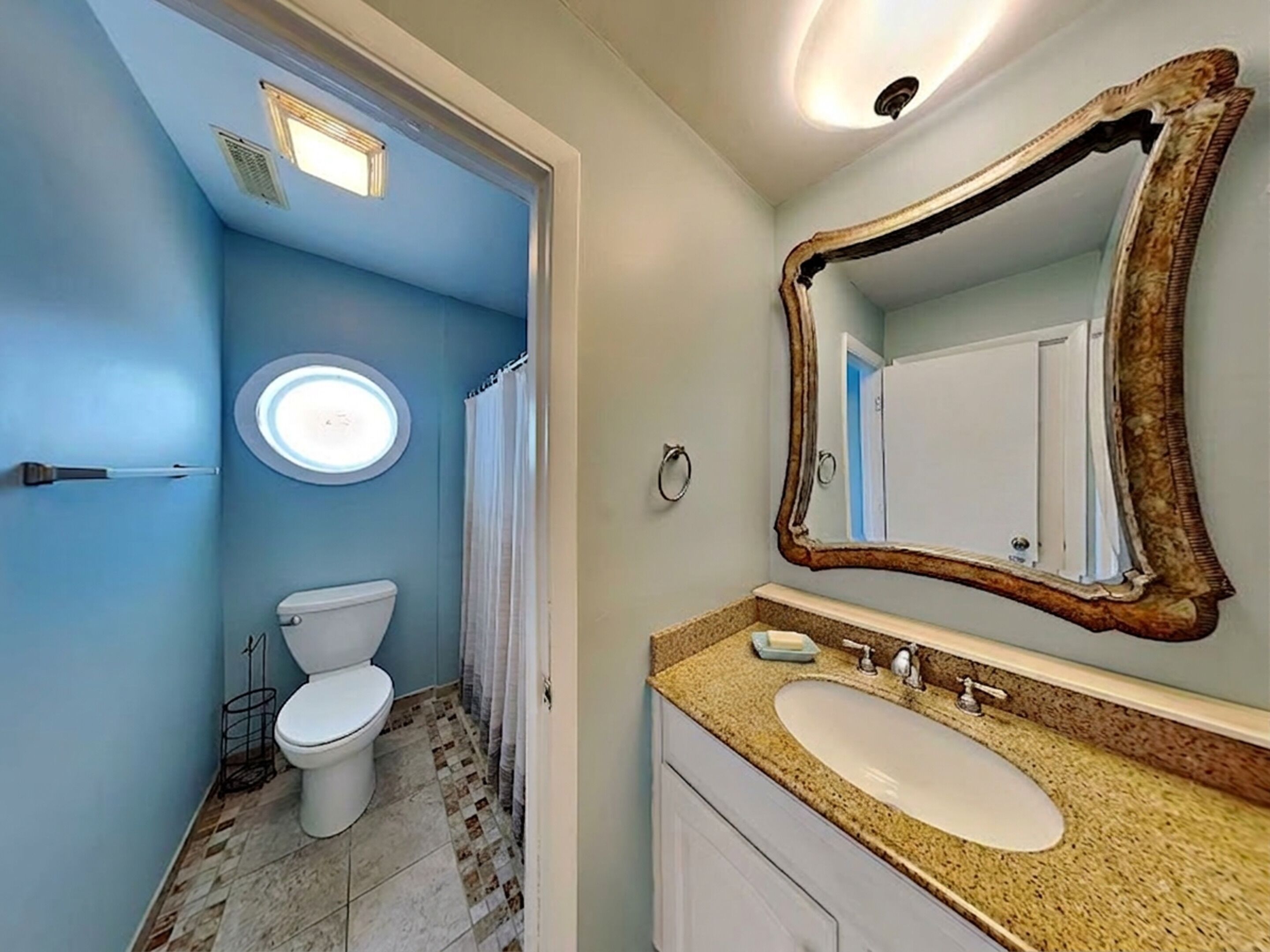 Een badkamer met toilet, wastafel en spiegel.