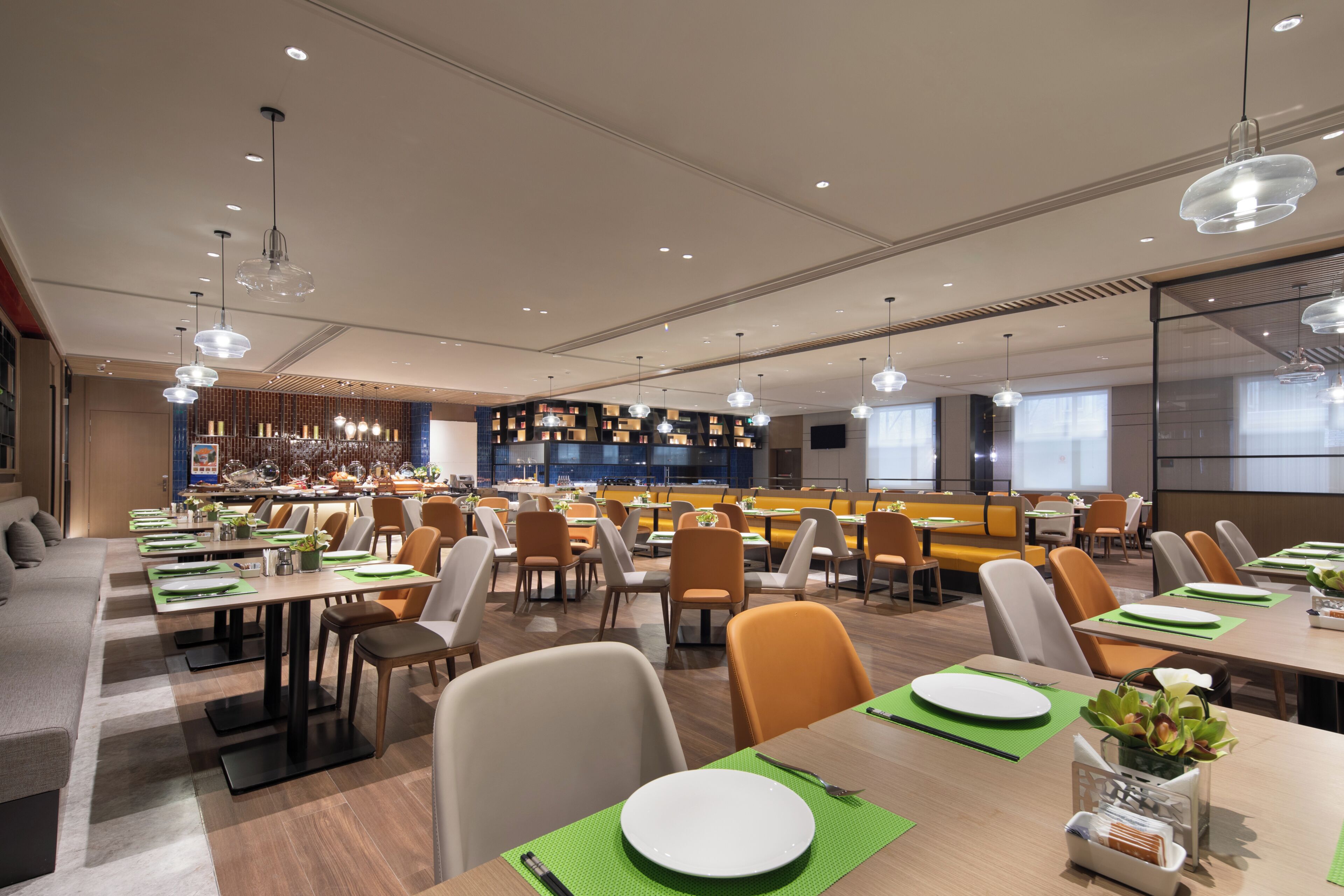 A modern dining area with multiple tables, chairs, and a bar area.