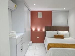 Ein Schlafzimmer mit einem Bett, einem Nachttisch, einem Kleiderschrank und einer Klimaanlage.