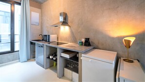 A compact kitchen with a built-in microwave, coffee maker, and a small refrigerator. - Antwerp Central Residence1bbknswifi (Antwerp)