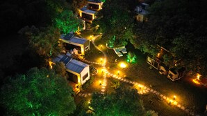 A cluster of small, modern cabins with solar panels, surrounded by trees and illuminated pathways. - Alya Hill Bodrum (Bodrum)