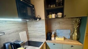 Eine kleine Küche mit Mikrowelle, Toaster und Obstschale auf der Arbeitsfläche.