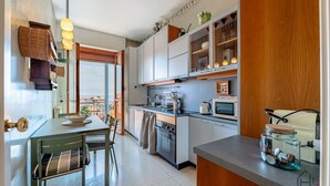 Une cuisine avec un coin repas, une vue par la fenêtre et un meuble en bois.