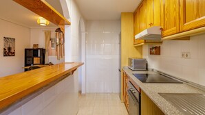 A kitchen with wooden cabinets, a built-in microwave, and a stainless steel sink. - 'Nomad House' Apartment with Shared Pool, Wi-Fi, and Air Conditioning (Gran Alacant)