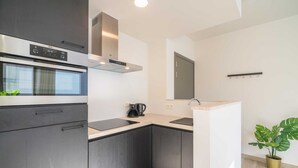 Een moderne keuken met een inbouwoven, een kookplaat en een afzuigkap.