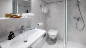 Ein modernes Badezimmer mit Waschbecken, Toilette und einer Duschkabine.