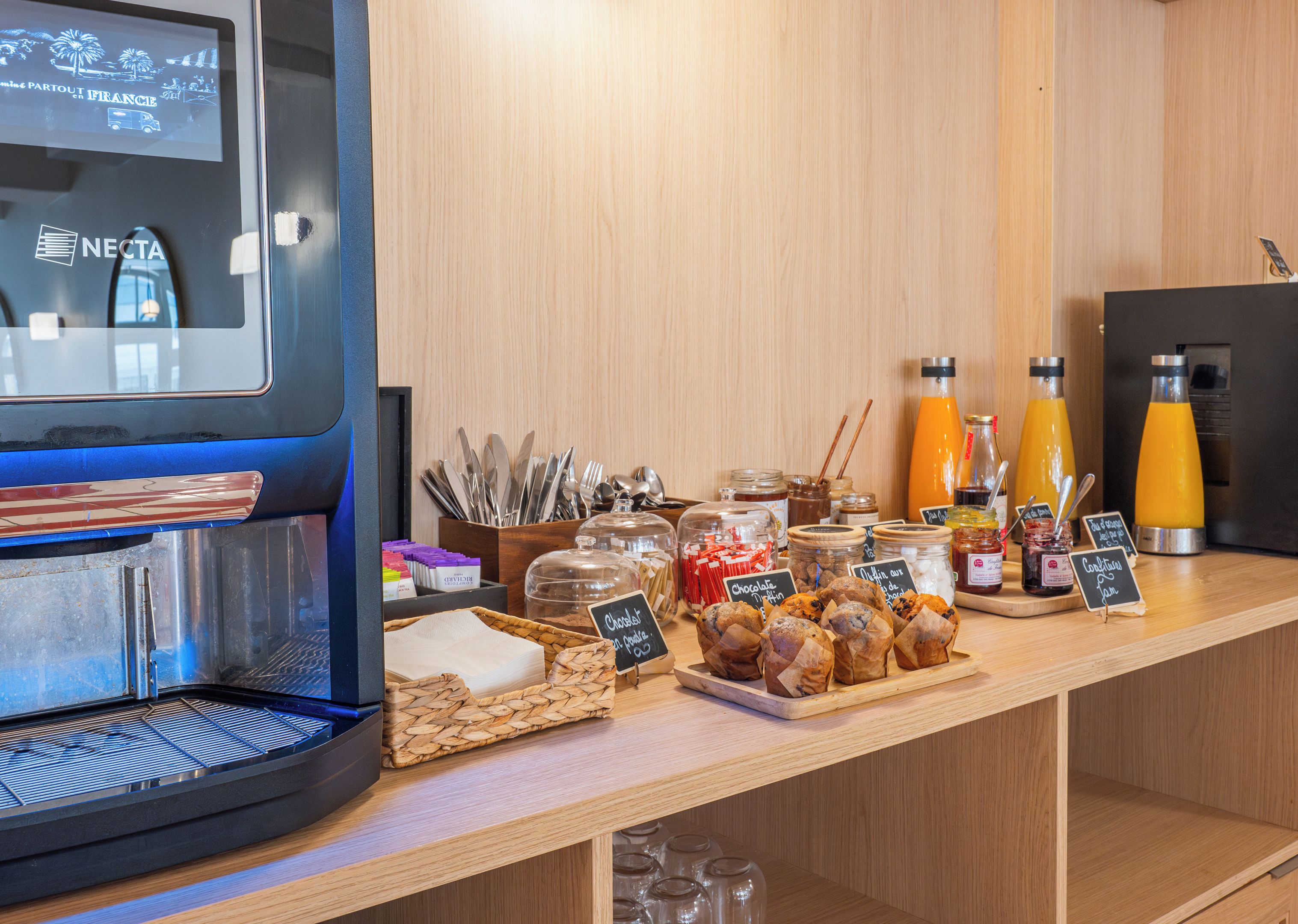 Un bufé de desayuno con diversas opciones de comida, salsas y una máquina de café.