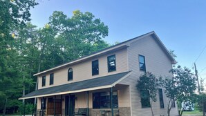 A two-story house with a covered porch, a garage, and a driveway.