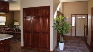 A spacious living area with a large wooden cabinet, a dining table, and a potted plant.