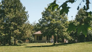 A house with a red roof, surrounded by trees and grass.