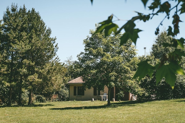 A house with a red roof, surrounded by trees and grass.