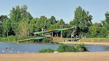 A water park with a water slide and a sandy area.