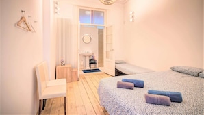 A bedroom with a bed, a chair, a small table, and a radiator. - Charming Bright Stone Lodge (Antwerp)