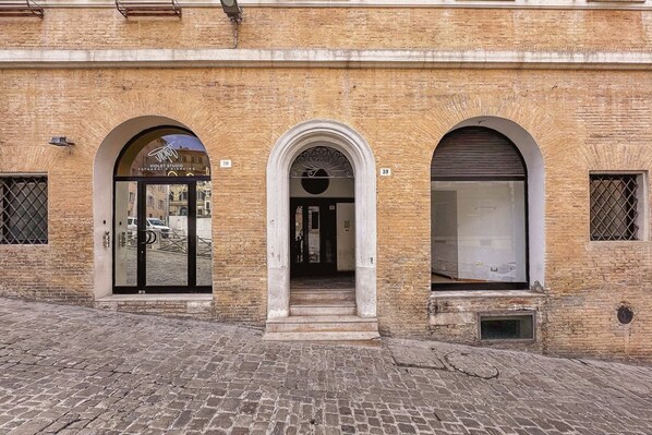 A building with three arched doorways, each marked with a number.