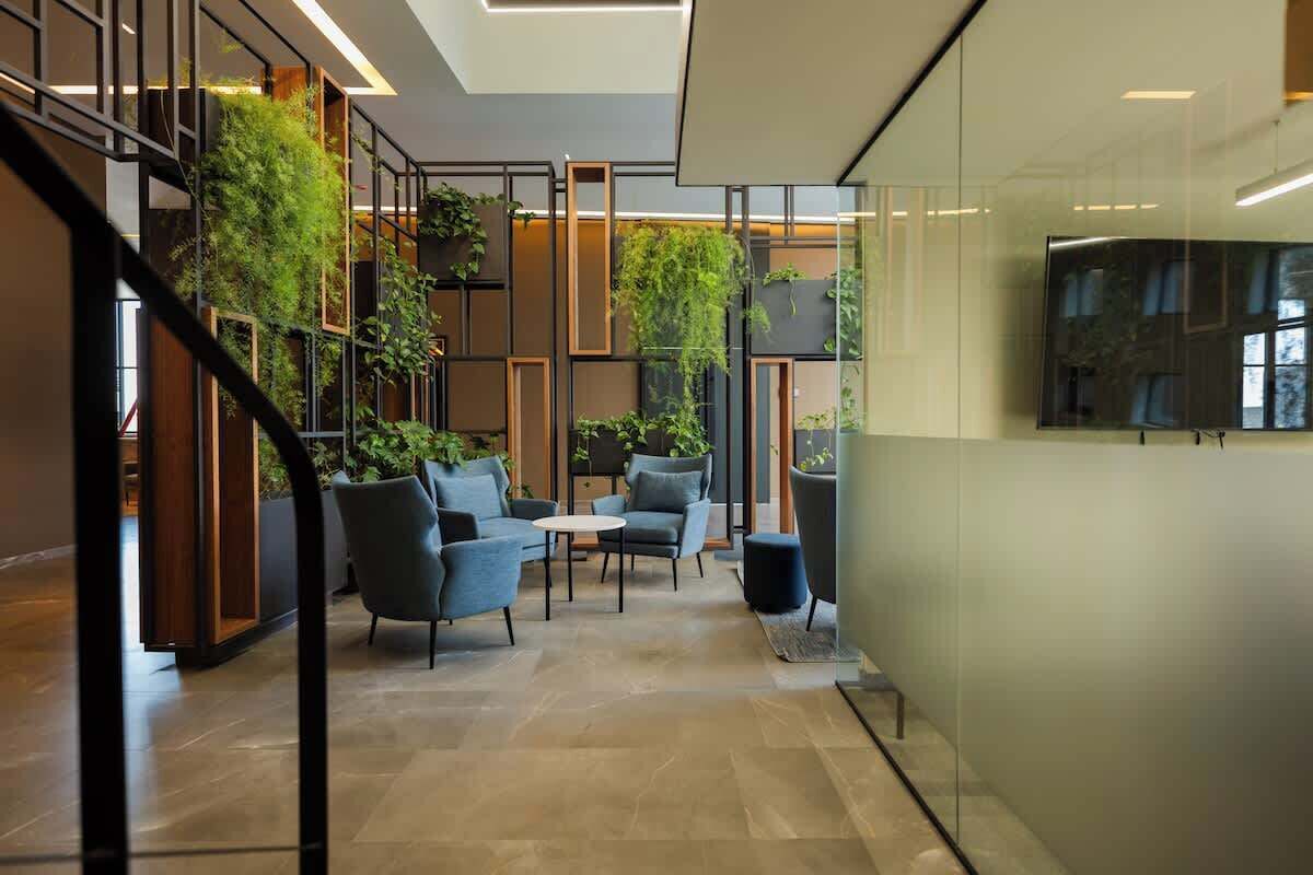 Un espace intérieur moderne doté d’un escalier, d’un coin salon et d’un grand téléviseur à écran plat fixé au mur.