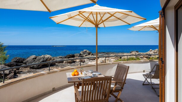 A balcony with a table set for two, two chairs, and two large umbrellas. - Villa 'Relax Cabrera Miramar' (Colònia de Sant Jordi)
