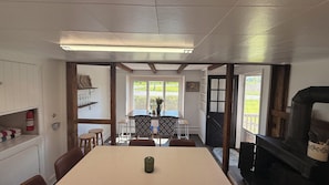 A dining area with a table, chairs, a fireplace, and a view through the window.