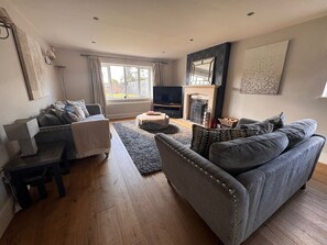 A living room with a sofa, a coffee table, a TV, and a fireplace. - Cheshire escape. Golf course location. Hot Tub. 4 Ensuite bathrooms. sleeps 10. (Macclesfield)
