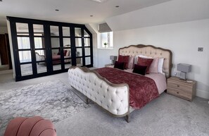 A bedroom with a large bed, a nightstand, a dresser, and a sliding glass door leading to another room. - Cheshire escape. Golf course location. Hot Tub. 4 Ensuite bathrooms. sleeps 10. (Macclesfield)