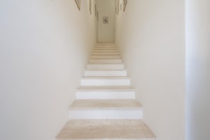 Una escalera que lleva a un rellano con un cuadro en la pared.