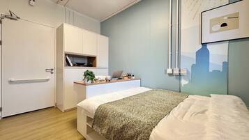 A modern bedroom with a bed, bedside table, and a cityscape artwork on the wall.
