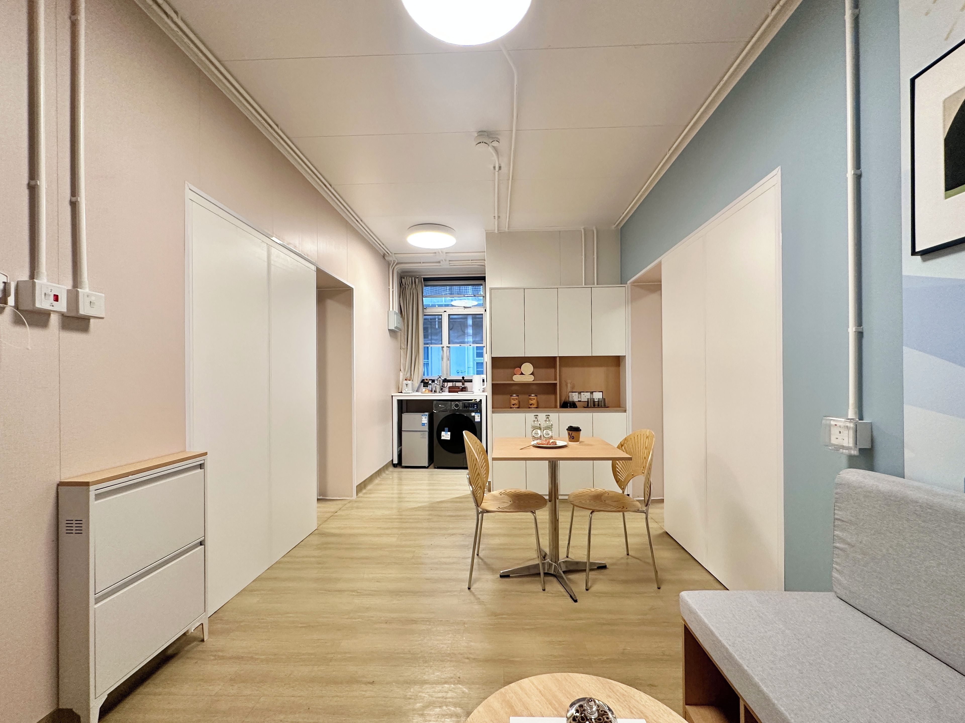 Un pasillo conduce a una kitchenette con comedor, un sofá y un ventanal con vistas.