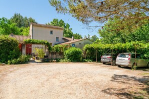 A house with a gravel driveway, parked cars, and lush greenery. - Sauge Room with Shared Pool, Wi-Fi, and Air Conditioning (Pernes-les-Fontaines)