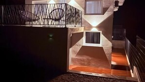 Una casa moderna con balcón, escaleras y garaje.