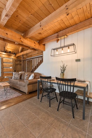 Un intérieur en bois comprenant un canapé, une table à manger, des chaises et un escalier.