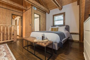 Ein Schlafzimmer mit Bett, Nachttisch und Fenster.