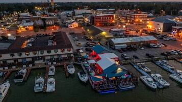 A marina with boats docked, a large building with a flat roof, and a small dock area.
