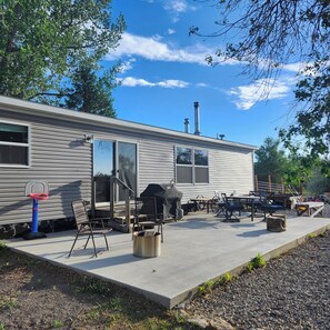 A mobile home with a basketball hoop, outdoor seating, and a chimney. - 4 Bedroom, 2 Bath Historical Homestead on the Bighorn River- Longwell Boat Ramp. (Thermopolis)