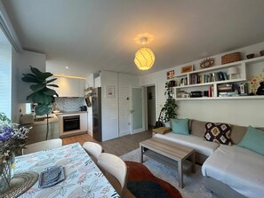 A modern living space with a kitchen, dining area, and a cozy seating area with a bookshelf. - Charming Sandymount APT Sleeps 4 (Dublin)