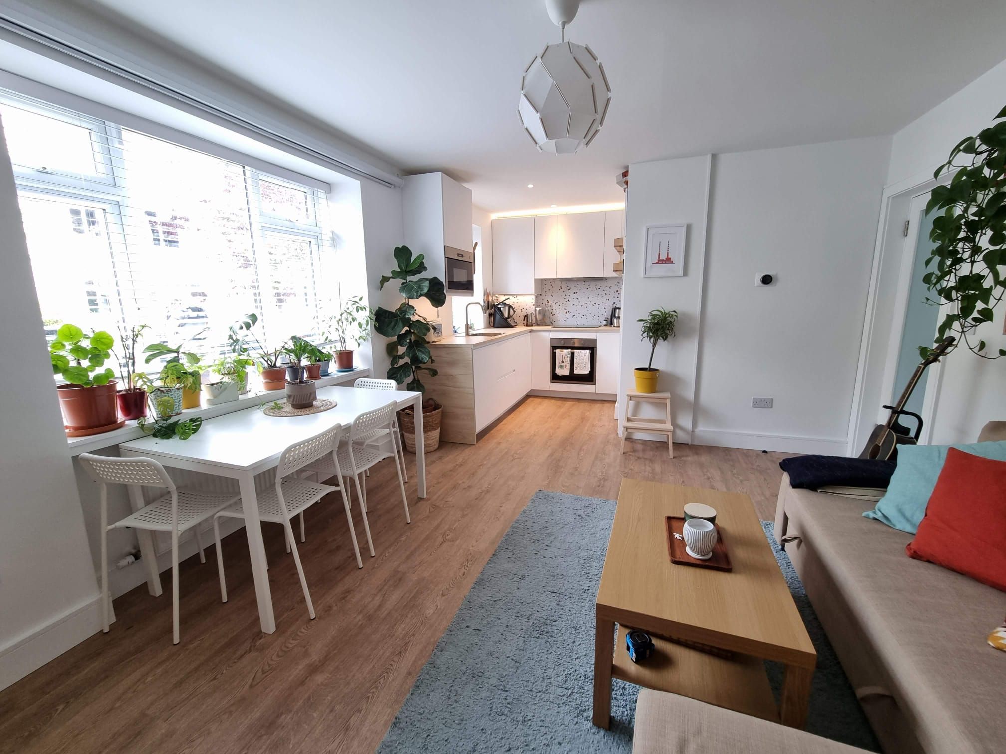 A modern apartment with a dining area, kitchen, and living space.
