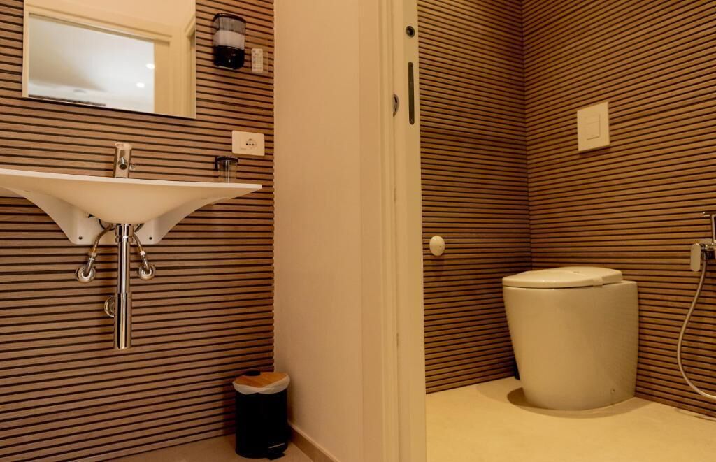 Un bagno con lavandino, wc e cestino.