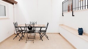 Un comedor con una mesa, sillas, una ventana y una barandilla.