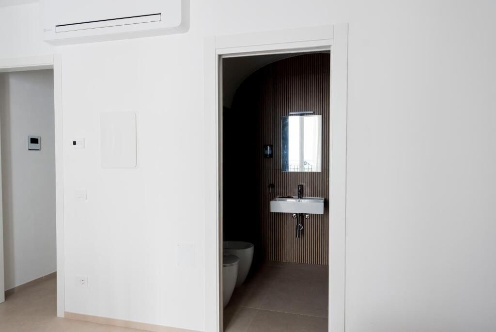 Un baño moderno con un lavabo blanco, un espejo y un inodoro.