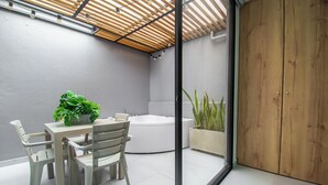 Une salle de bain moderne dotée d’une baignoire, d’une douche et d’un espace clos par des parois de verre, avec un plafond en bois.