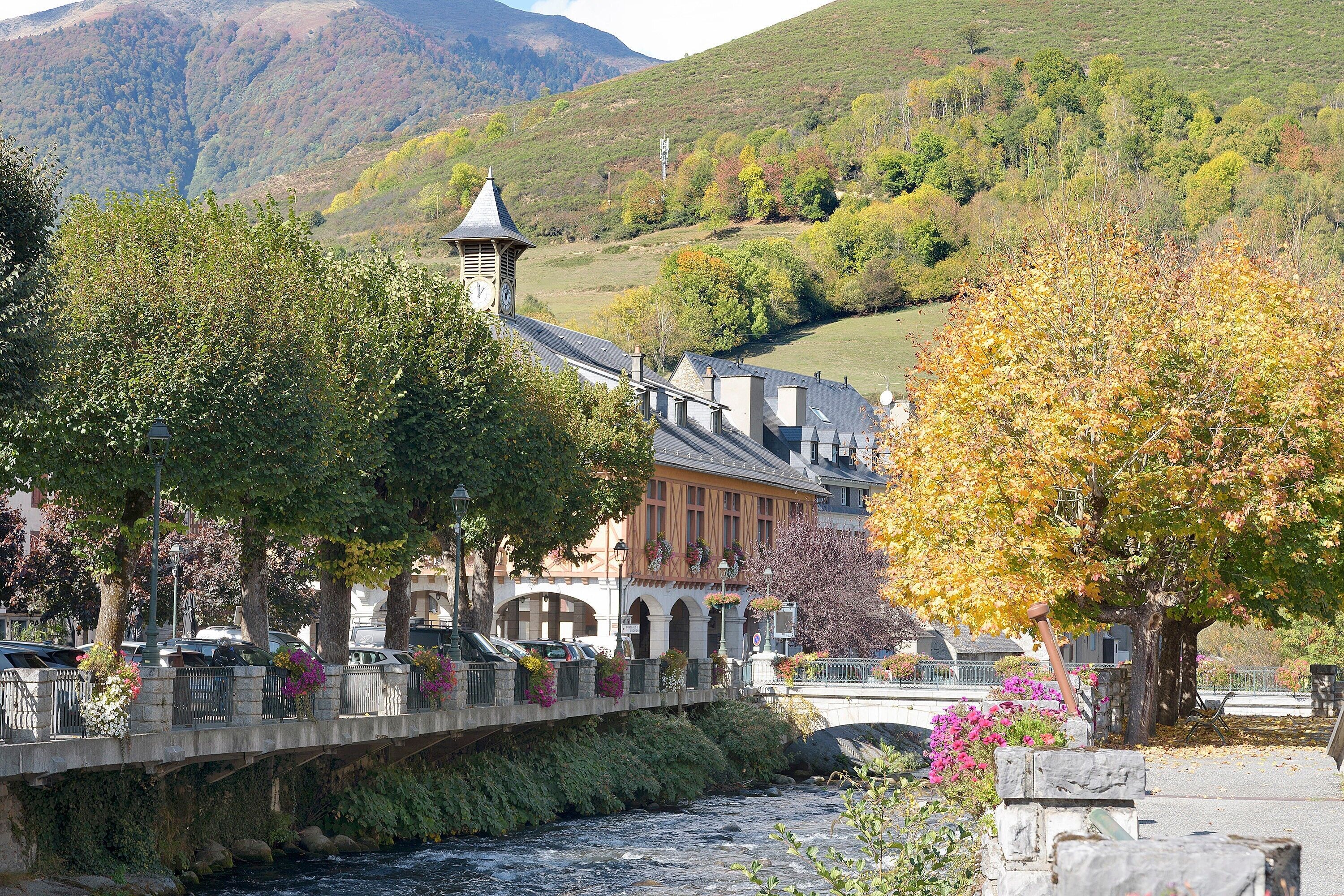 Une ville riveraine dotée d’un pont, de bâtiments historiques et d’une tour de l’horloge.