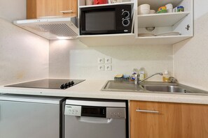 A kitchen with a microwave, dishwasher, and sink.