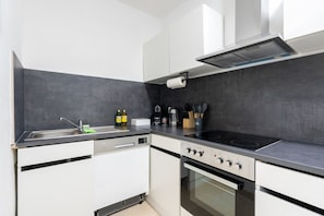 A modern kitchen with a dishwasher, stove, oven, and a sink with a faucet. - 55 m² I 2 Rooms I Up to 5 Guests I Near Vienna (Kaltenleutgeben)