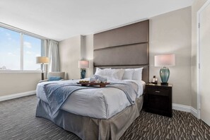A hotel room with a large bed, two bedside tables, a window with curtains, and a view of the city. - Gallery One  Spa  Heated Pool   Boat Taxi (Fort Lauderdale)