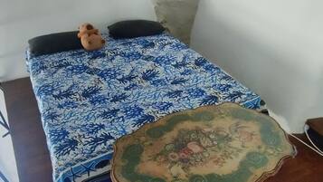 Tabla de planchar con plancha y ropa de cama